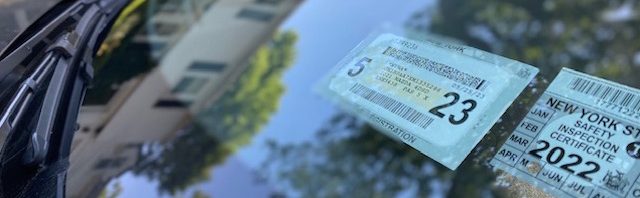 Car registration and inspection stickers on windshield.