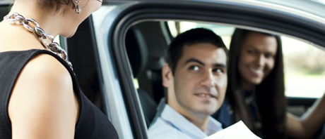 Person handing documents to car owner