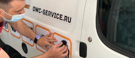 Person working on a van with JCB OWC Service branding.